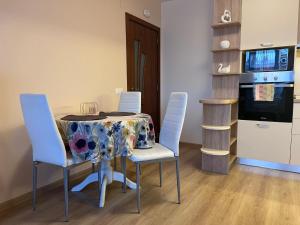 a kitchen with a table and chairs with a table cloth at Cappuccino apartment in Sofia
