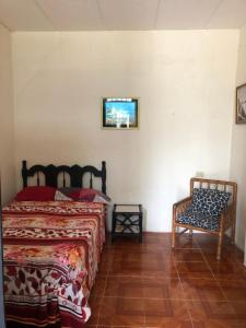 een slaapkamer met 2 bedden en een stoel bij hospedaje Maluli suit 2 in Santa Elena