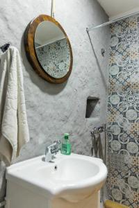 uma casa de banho com um lavatório e um espelho em Old House Piperi em Podgorica