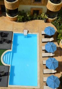 an overhead view of a swimming pool with blue umbrellas at EWG Golden Sea Hotel Obhur in Jeddah