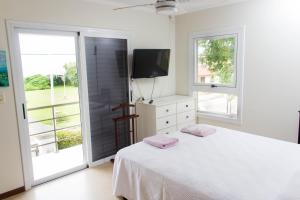 Un dormitorio blanco con una cama y un televisor. en Casa Gardenia Federación ER, en Federación