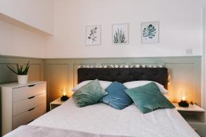 a bedroom with a bed with three pillows on it at Central Retreat in Cardiff