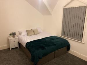 una camera da letto con un letto con una coperta verde sopra di Riverside by Teil a Preston