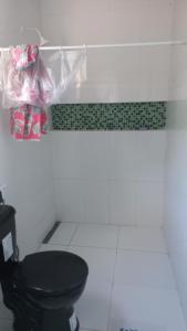 a bathroom with a black toilet in a room at Pousada Carvalho in Salinópolis
