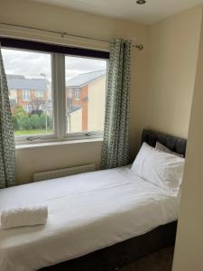 a bed in a room with a large window at Angelica House in West Derby