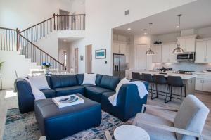 a living room with a blue couch and a kitchen at Galveston Beach House w Water Views & New Pool in Galveston