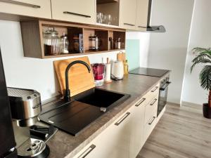 una cucina con lavandino e piano di lavoro di Summer Haven- self check-in, parking, netflix, terrace, near mall a Oradea