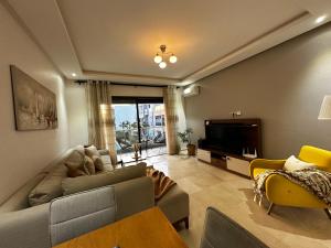 salon z kanapą i telewizorem w obiekcie Ocean Palm Aρραrt Pοοl Vieω w mieście Casablanca