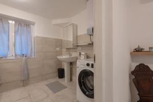 a bathroom with a washing machine and a sink at Appartamento San Rocchino 37 - Affitti Brevi Italia in Genova