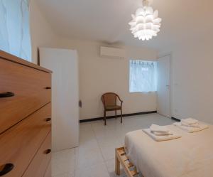 ein Schlafzimmer mit einem Bett, einem Stuhl und einem Kronleuchter in der Unterkunft Appartamento San Rocchino 37 - Affitti Brevi Italia in Genua