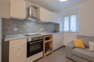 a kitchen with a stove top oven next to a couch at Appartamento San Rocchino 37 - Affitti Brevi Italia in Genova