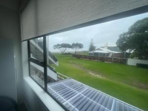a window of a house with a view of a yard at Ohope Dreamer 1 in Ohope Beach