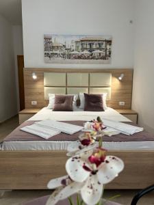 1 dormitorio con 1 cama grande con flores blancas en Apartments Sija, en Ulcinj