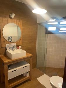 a bathroom with a sink and a mirror at Hotel Pousada Bella Locanda in Campos do Jordão