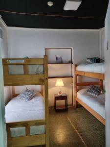 Zimmer mit 2 Etagenbetten und einer Lampe in der Unterkunft Alojamiento Emilia House in Punta Arenas