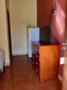 uma cozinha com um frigorífico e uma cómoda com uma televisão em Hotel-Balneario Acuamanía em Hernandarias