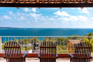 two chairs sitting on a porch looking out at the ocean at Hotel San Juan in Puerto Escondido