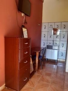 um quarto com uma secretária e uma cómoda com uma televisão na parede em Hotel-Balneario Acuamanía em Hernandarias