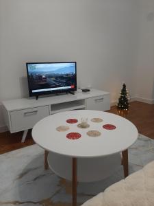 Il comprend un salon doté d'une table blanche et d'une télévision. dans l'établissement Oaza 2, à Banja Luka