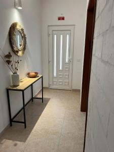a hallway with a table and a mirror and a door at Casa da Vila - Malhadais in Odeceixe +44 photos
