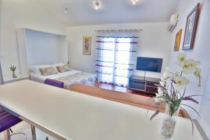 - un salon avec un lit et un vase de fleurs dans l'établissement Summer lounge Split, à Split