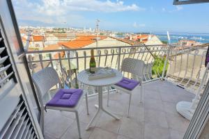 - une table et des chaises sur un balcon avec une bouteille de vin dans l'établissement Summer lounge Split, à Split
