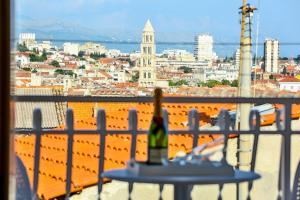 uma garrafa de vinho sentada numa mesa na varanda em Summer lounge Split em Split