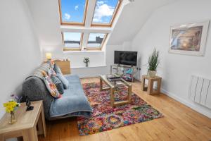 a living room with a couch and a table at Stunning 2BR Loft Apt in Oban - Sea Views in Oban