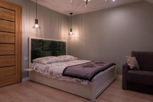 a bedroom with a bed and a couch and lights at GOLD apartamenty & spa in Szczawnica