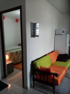 uma sala de estar com um sofá e um quarto em Un T2 climatisé, une nuit em Kourou