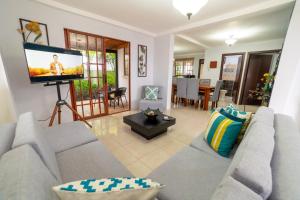 ein Wohnzimmer mit einem Sofa und einem Flachbild-TV in der Unterkunft Markinkia - Estancia Amazónica in Macas