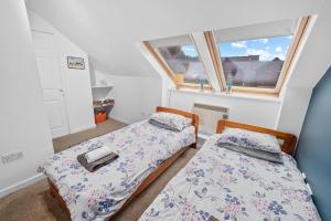 two beds in a small room with a window at Argyll Apartments - High Street, Oban in Oban