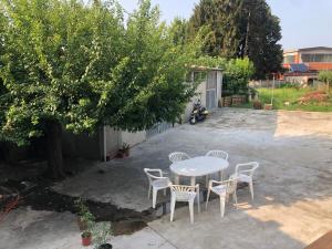 una mesa y sillas en un patio con un árbol en Stanze private in villa, en Turín