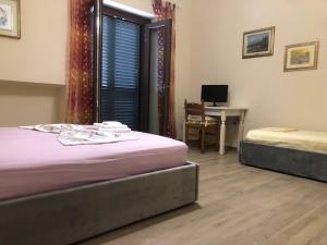 Habitación con 2 camas, escritorio y mesa. en Stanze private in villa, en Turín