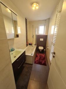 a bathroom with a tub and a sink and a toilet at Terrassenwohnung Heidenheim an der Brenz in Heidenheim