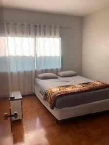 Apartamento em Passo Fundo في باسو فوندو: غرفة نوم بسرير كبير ونافذة