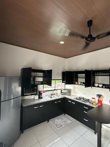 a large kitchen with black cabinets and a ceiling at Apartamento Rodriguez in Quepos
