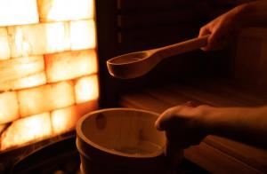 a person holding a cup and a wooden spoon at GOLD apartamenty & spa in Szczawnica