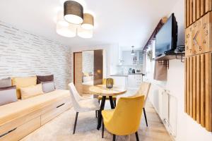 a living room with a table and chairs and a kitchen at Wellness Apartmány Andrea in Zdíkov