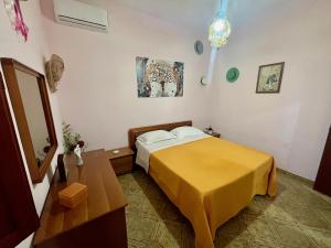 a bedroom with a bed with a yellow blanket at La Casa di Luisa Alloggio Familiare 3 camere in Vico Equense