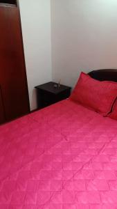 a bed with a pink comforter in a room at Apartamento Ciudad Salitre Bogota - Amoblado in Bogotá