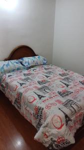 a bed with a flowered blanket on top of it at Apartamento Ciudad Salitre Bogota - Amoblado in Bogotá