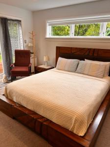 1 dormitorio con 1 cama grande y 1 silla en The perfect getaway for two in a large suite en Whanganui