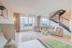 a living room with a couch and a staircase at Yuna Porte-Maillot - ApartHotel in Paris