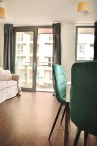 a living room with two green chairs and a couch at Venice Court London in London