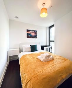 a bedroom with a large bed with towels on it at Venice Court London in London