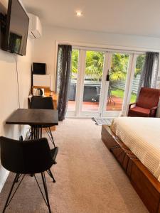 1 dormitorio con cama, escritorio y mesa en The perfect getaway for two in a large suite en Whanganui