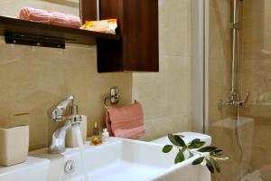 a bathroom with a white sink and a shower at Venetian Suite Mitropolis new in Corfu +15 photos