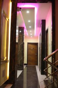 a hallway with purple lights and a door at Hotel Shangri-La in kolkata