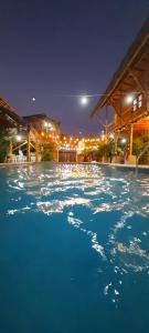 a large swimming pool with blue water at night at Hostal El Cascol in Puerto López